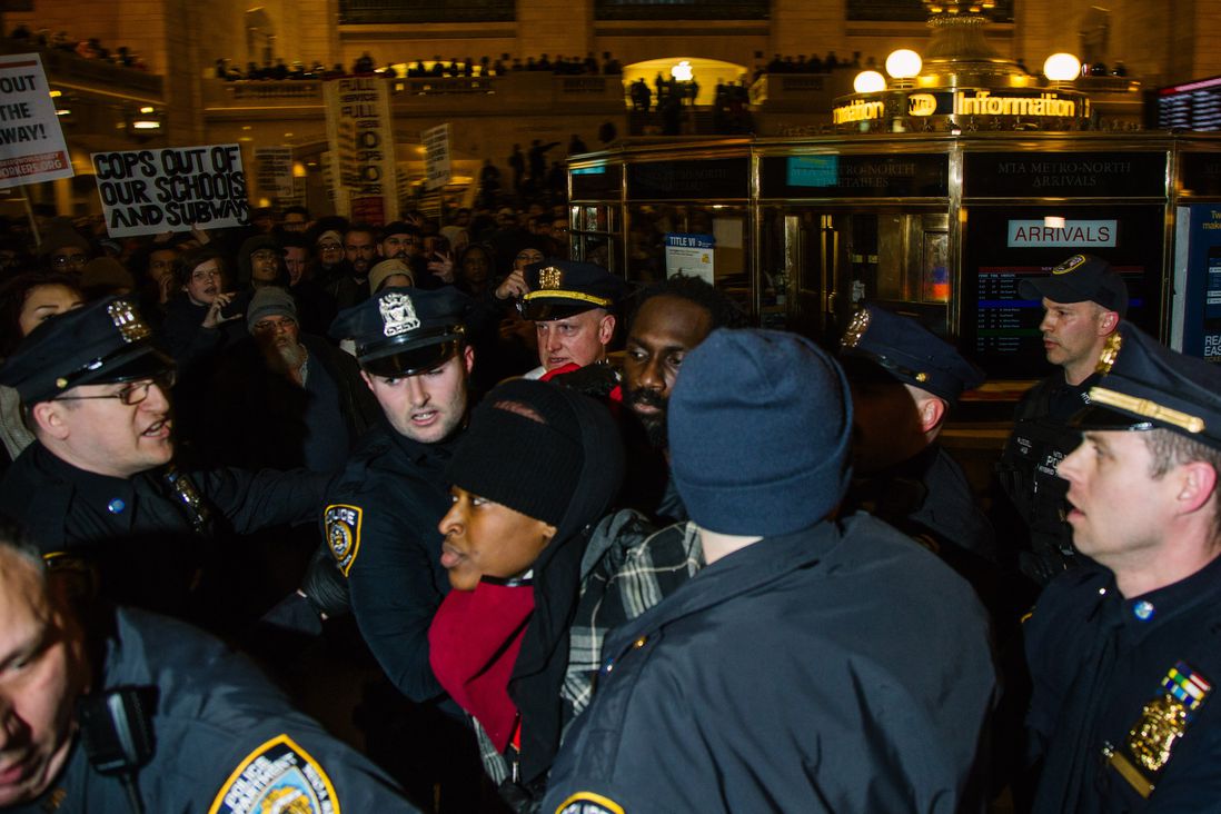 A protester is detained in Grand Central on Friday night.